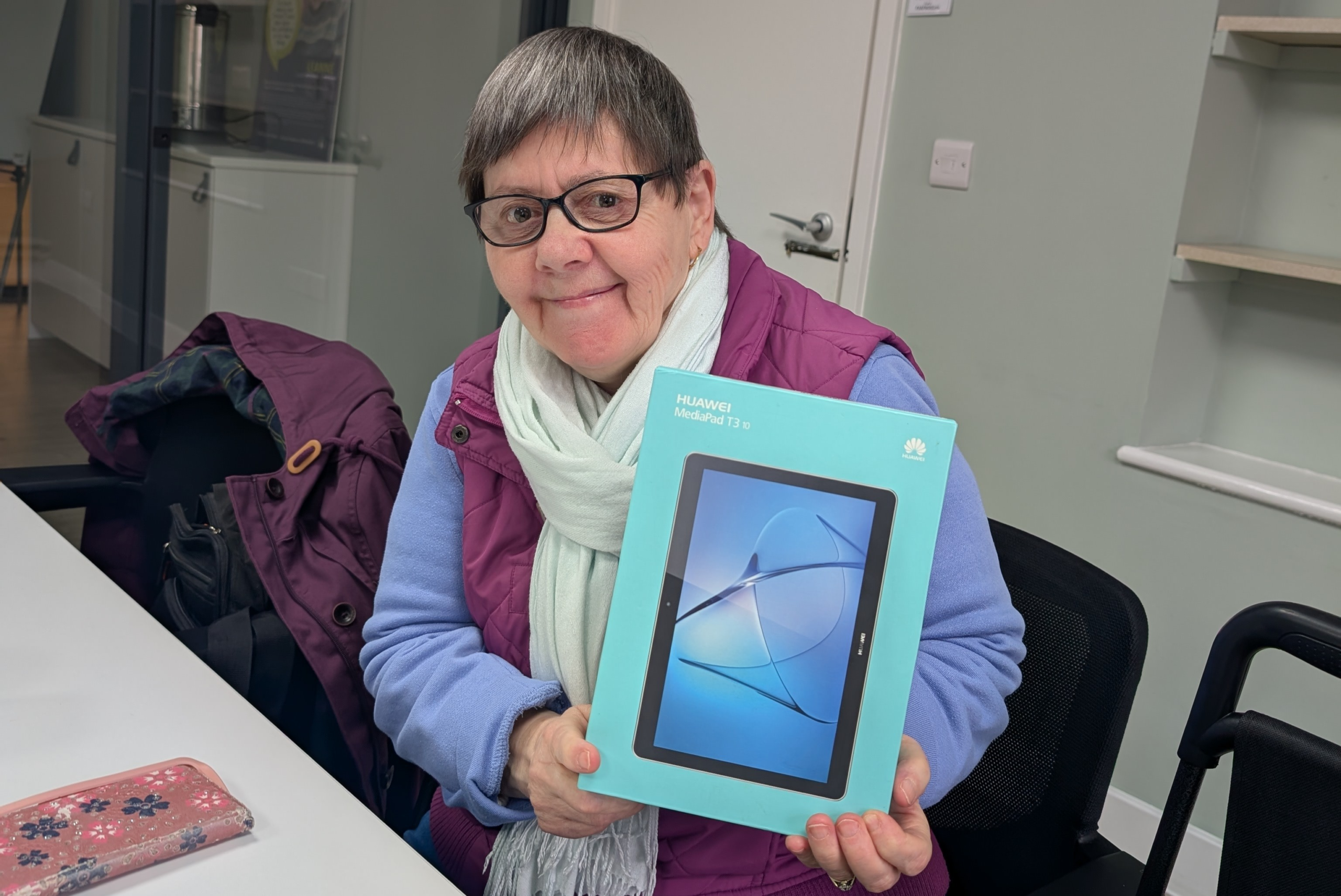 A woman holding up a new tablet digital device 